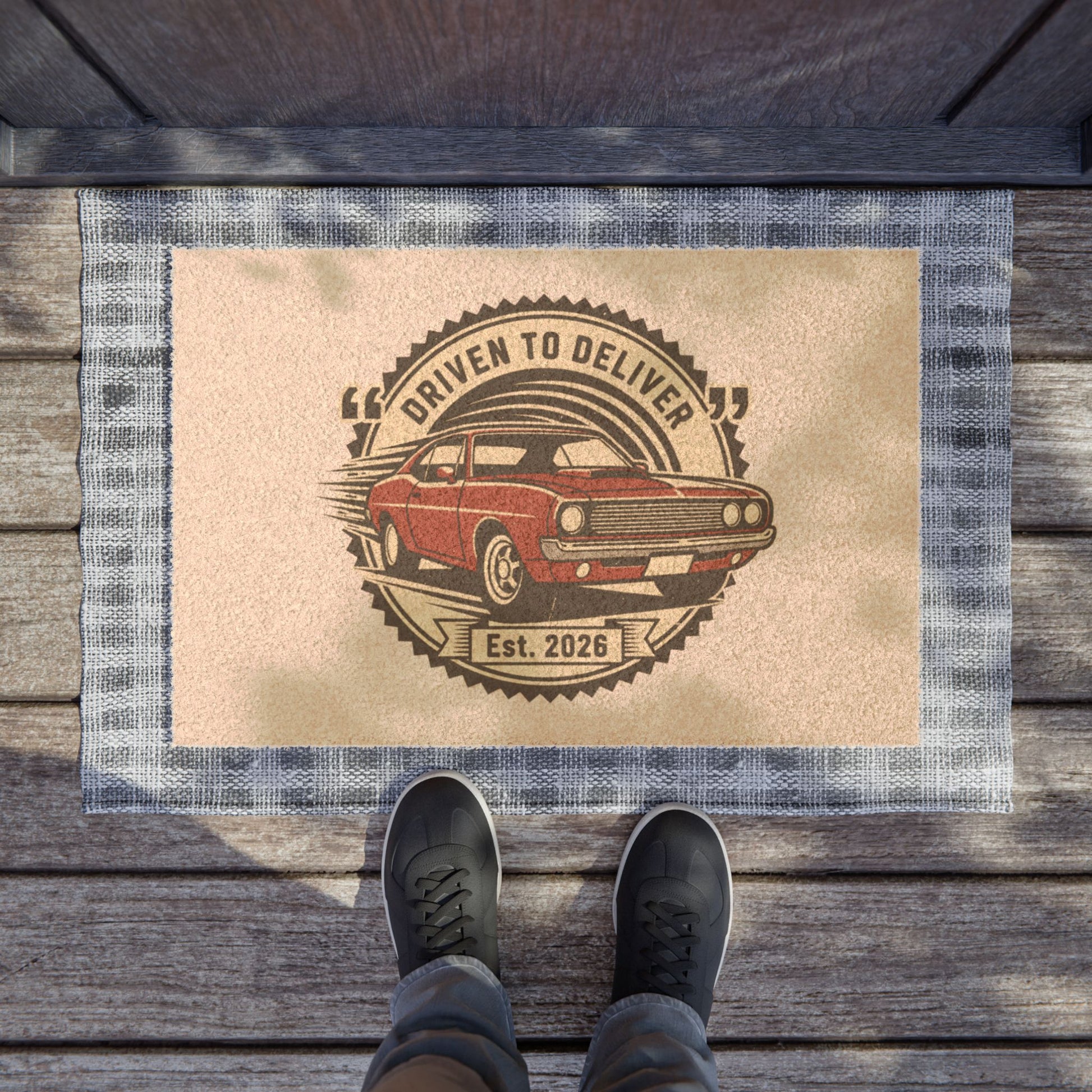 Doormat with a car design and text on a wooden floor